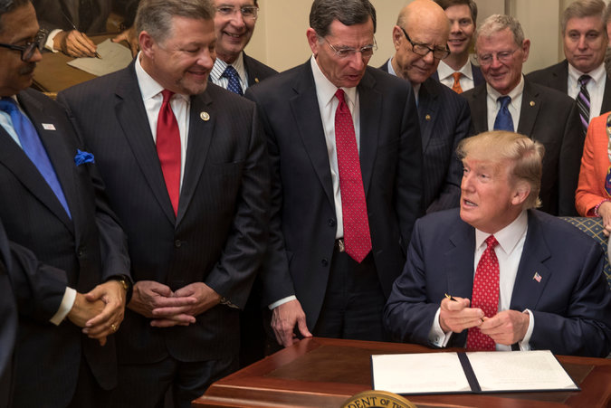  President Trump signing back-to-back executive orders last week in Washington. Credit Stephen Crowley/The New York Times 