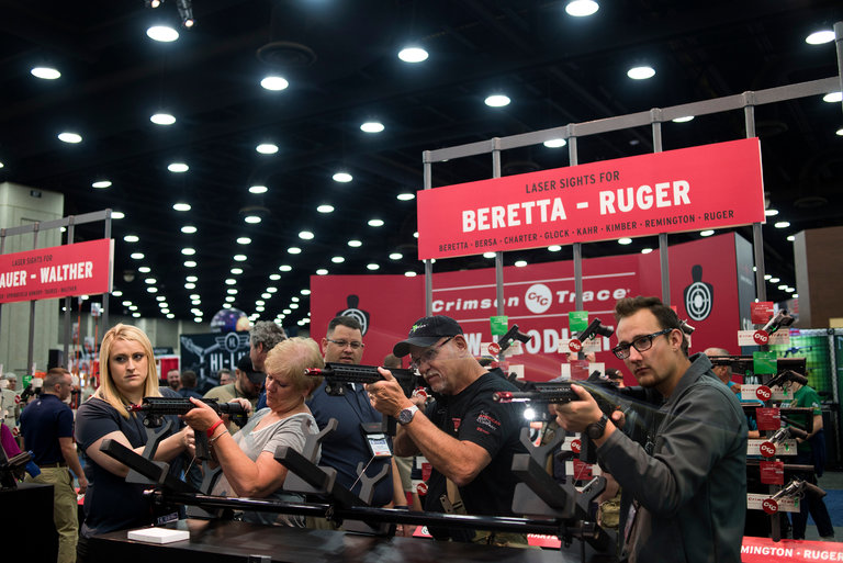  People shooting firearms at a screen at an exhibit last May during the National Rifle Association Convention in Louisville, Ky. The gun-rights group lobbied against a rule that would have effectively prevented most people with disabling mental illnesses from purchasing firearms. Credit Ty Wright for The New York Times 